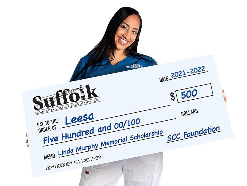 Women holding a giant check for scholarship fund