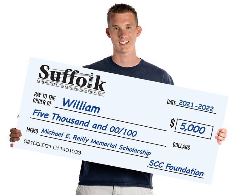 Man holding a giant check for scholarship fund