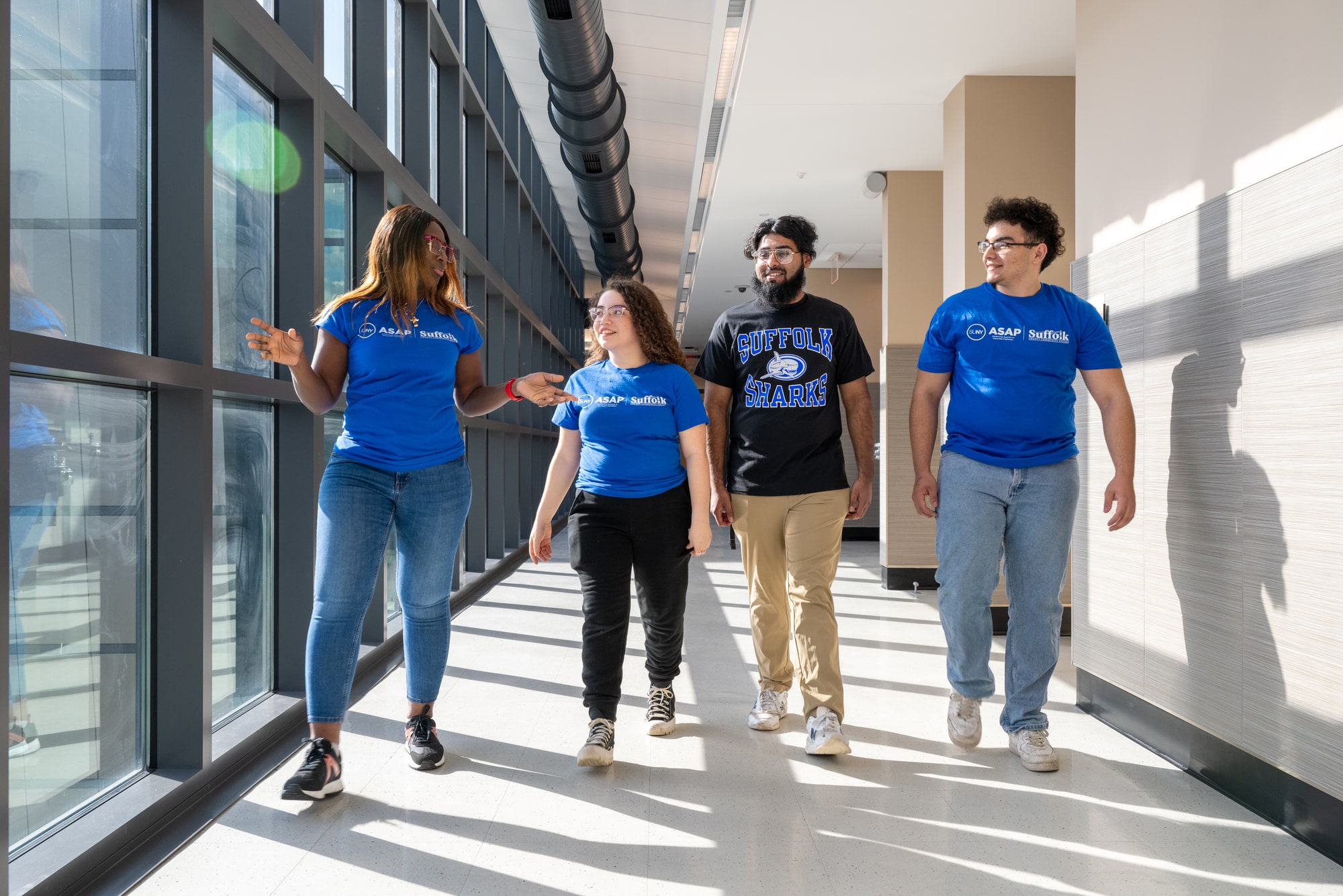 Group of four students walking down a hallway at Suffolk Ammerman campus.