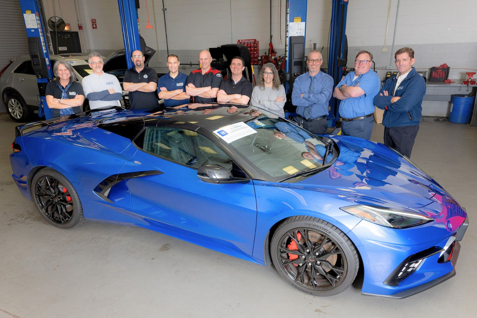 Blue car donated by General Motors with faculty standing behind the car